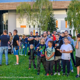 Urodziny Mościc - Grupa ludzi stoi na trawie obok hali Jaskółka.  - Fot. Przemysław Sroka i Michał Żurowski