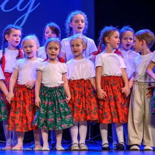 Mali Świerczkowiacy i Przyjaciele - Dziewczynki i chłopiec z zespołu pieśni i tańca stoją na scenie i śpiewają. - Fot: Przemysław Sroka