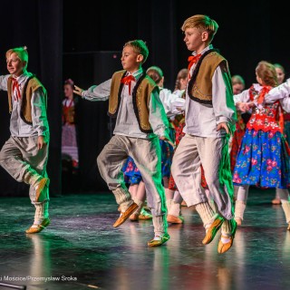 Mali Świerczkowiacy i Przyjaciele - Członkowie zespołu, ubrani w barwne stroje ludowe, tańczą na scenie. - Fot: Przemysław Sroka