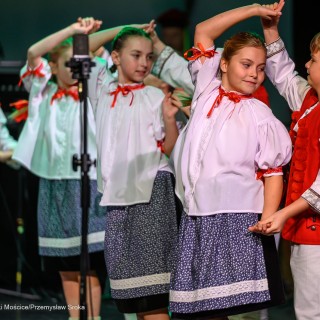 Mali Świerczkowiacy i Przyjaciele - Dzieci ubrane w stroje ludowe tańczą w parach na scenie. - Fot: Przemysław Sroka