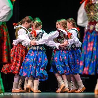 Mali Świerczkowiacy i Przyjaciele - Dziewczęta ubrane w barwne stroje ludowe tańczą na scenie. - Fot: Przemysław Sroka