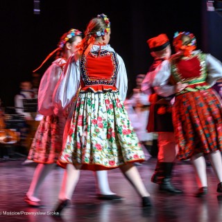 Mali Świerczkowiacy i Przyjaciele - Dzieci ubrane w barwne stroje ludowe tańczą w parach na scenie. - Fot: Przemysław Sroka